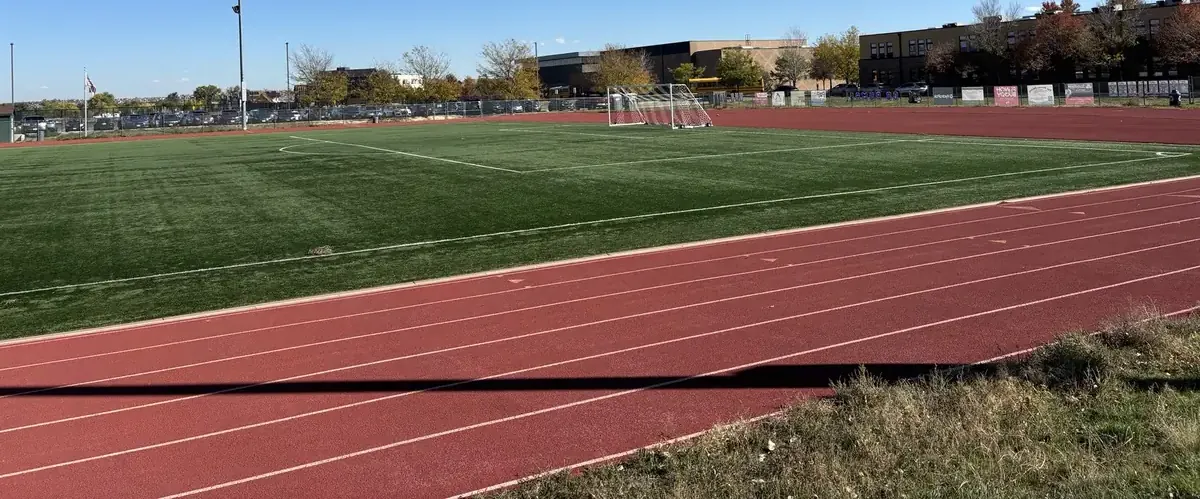 Pista de atletismo em torno de um relvado, vista do alto das bancadas