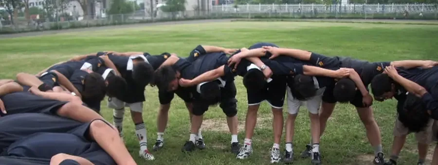 Jogadores de râguebi em círculo de aquecimento antes do treino